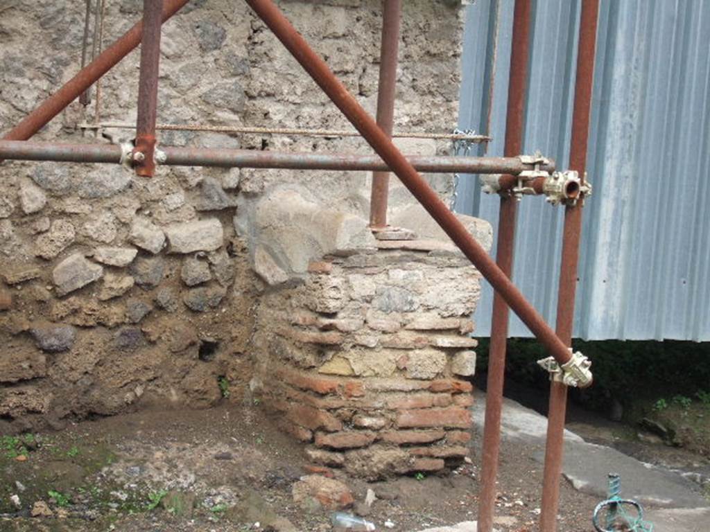 Street altar outside IX.12.7.  December 2005. West and south sides. According to Fr�hlich all three sides were originally decorated. On the west side was a red sausage on a skewer. On the South side to the left was a pig's head in profile and to the right was an older, translucent pig's head. See Fr�hlich, T., 1991. Lararien und Fassadenbilder in den Vesuvst�dten. Mainz: von Zabern. (p. 339, F71, T: 58,2). 