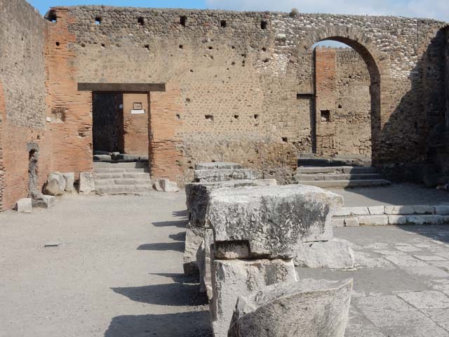 Arched entrance in north-west corner of Forum. May 2010. Looking through Arch of Augustus to the arched entrance with its steps.