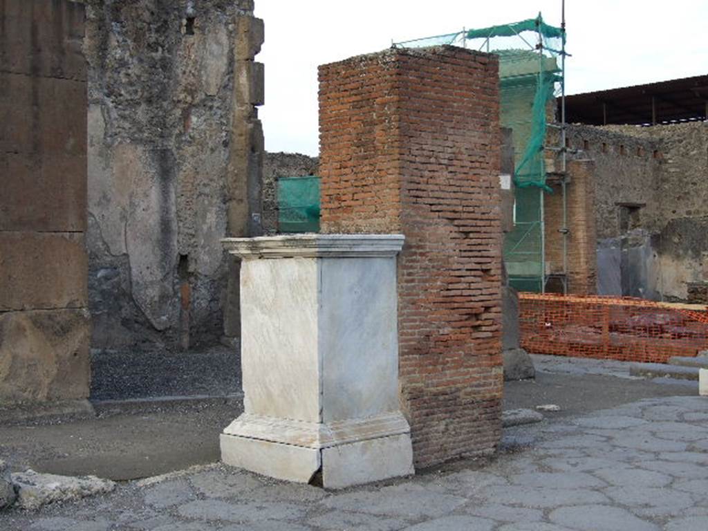 Arch of Marcus Holconius Rufus. December 2006. North west pillar with marble statue base. The brick pillar was one of the four pillars supporting the arch over Via dell� Abbondanza. The base when excavated in 1853 had a statue of Marcus Holconius Rufus. The statue is now in Naples Archaeological Museum.  