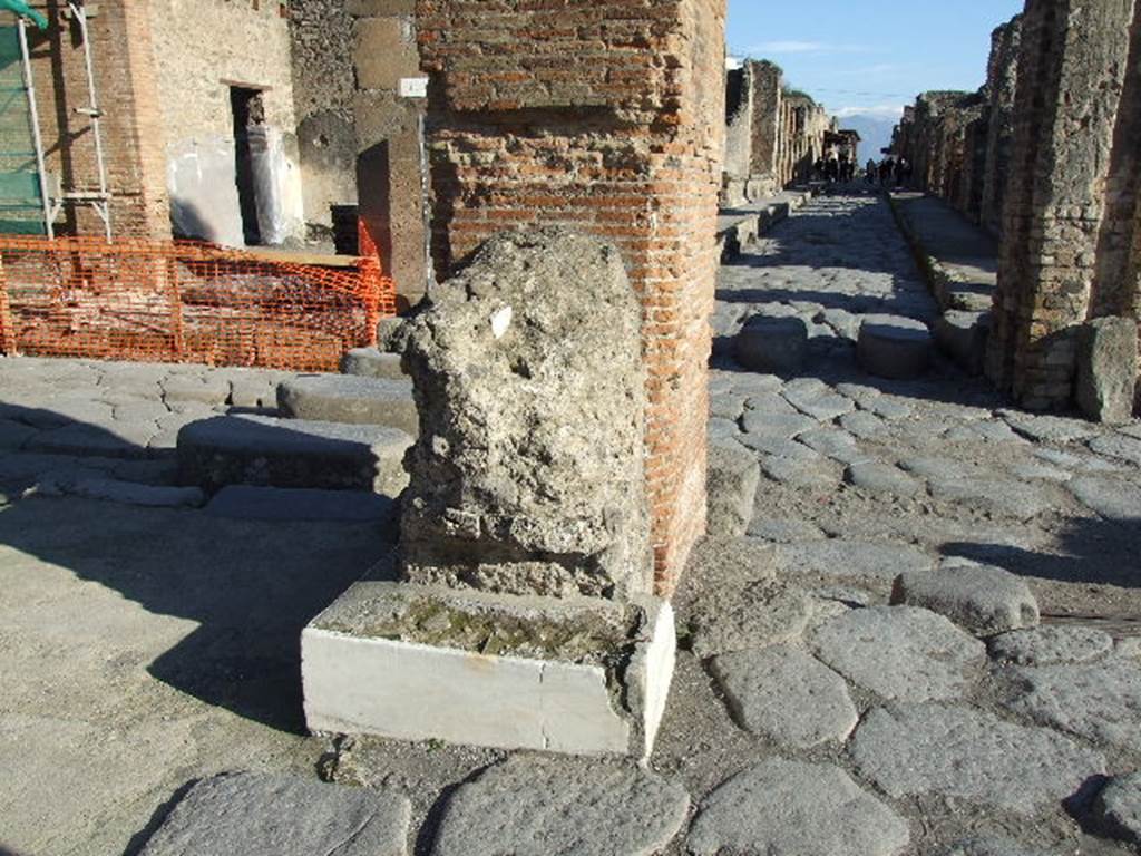 Arch of Marcus Holconius Rufus. December 2006. North-east pillar with remains of another statue base. Looking east along Via dell�Abbondanza.