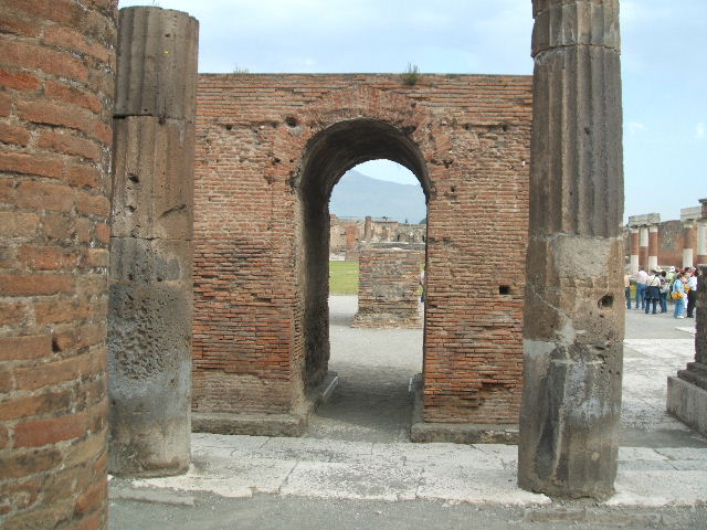 Arched monument at south end of Forum. May 2010. Photo courtesy of Rick Bauer. According to Mau, these four monuments were of the imperial family. The arched monument was probably the pedestal for a colossal statue of Augustus. The wide statue base on the right was for a colossal equestrian statue of Claudius. The wide base on the left was for a colossal standing statue of Agrippina. The smaller base (the nearest in this photograph) was for the smaller equestrian statue of Nero. None of these statues survive. See Mau, A., 1907, translated by Kelsey F. W. Pompeii: Its Life and Art. New York: Macmillan. (Page 47, Plan II).