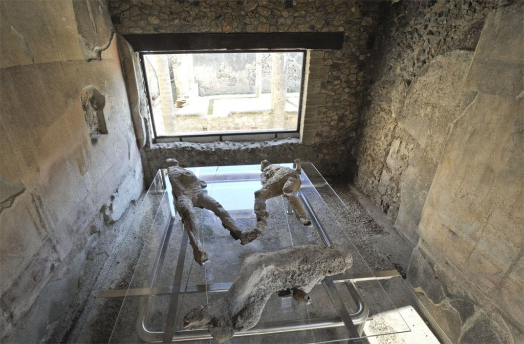 VII.1.47 Pompeii. March 2017. Room 8, looking across plaster-casts towards window in east wall.
The plaster-cast of victims 1 and 4 can be seen in the centre of the photograph, below them are the fractured remains of the plaster-cast of victim 2.
They were found in the Vicolo degli Scheletri.