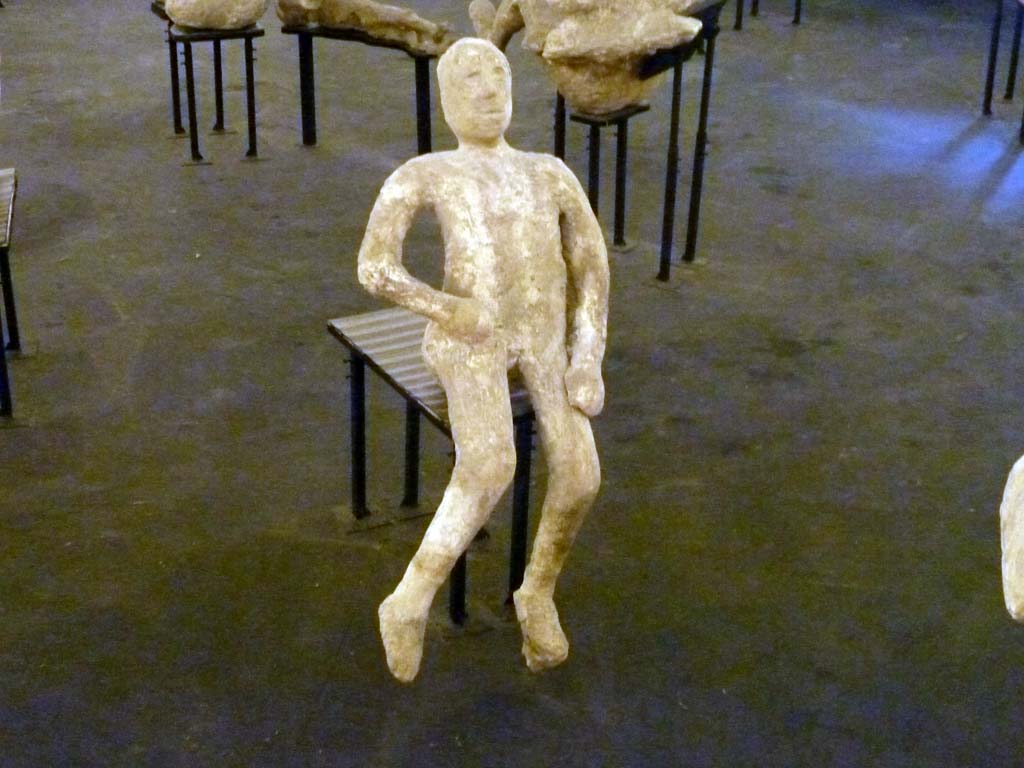 Victim 48 from VII.16.17-22 Pompeii. September 2015. Exhibit from the Summer 2015 exhibition in the amphitheatre.
Plaster cast of uppermost victim found huddled together with the others on the stairs that led to the ground floor.
The victim was male, aged 14-20 years or more.
The body was spread over three steps of the stairs. Its left leg covered the head and part of the upper body of Calco H.
The body of victim 48, overall, appears artificial and nowhere do natural anatomical details appear.
See Osanna, N., Capurso, A., e Masseroli, S. M., 2021. I Calchi di Pompei da Giuseppe Fiorelli ad oggi: Studi e Ricerche del PAP 46, p.432-3, Calco n. 48.