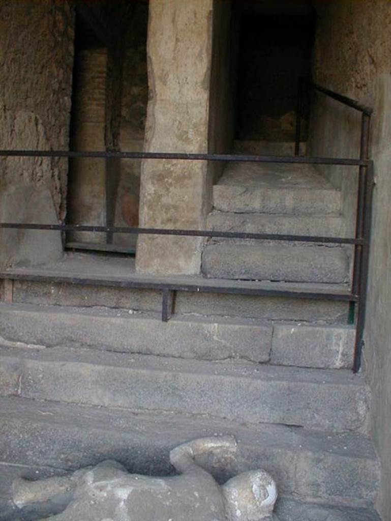 VII.16.17-22 Pompeii. May 2006.
Looking up towards the stairs where a group of fugitives were found, and where victim 49 still lies at the foot of staircase.