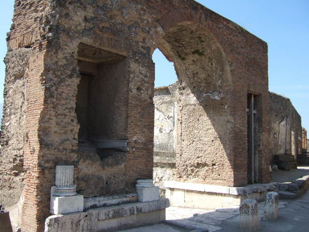 Fountain in arch at north-east corner of Forum. May 2006. Looking south-west.
Nach Eschebach: Die Brunnenbecken am Bogen waren in Gestalt eines Nymph�ums mit Grottennischen in Marmor inkrustiert. 
According to Eschebach: The fountain basins in the arch were in the form of a nymphaeum with grotto niches clad in marble. 
See Eschebach, H., 1983. Pompeii, Herculaneum, Stabiae; Bollettino dell�Associazione Internazionale Amici di Pompei 1, p. 26, fig. 37. 
