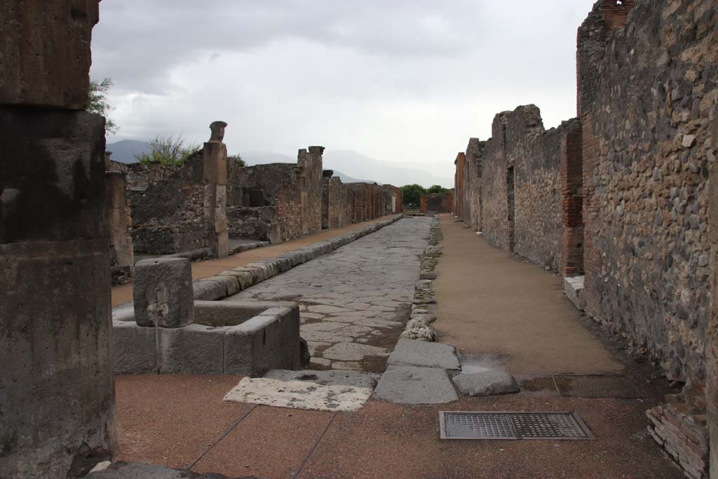 Outside VIII.2.11, Pompeii. December 2005. Looking north past fountain on Via delle Scuole, towards Forum.