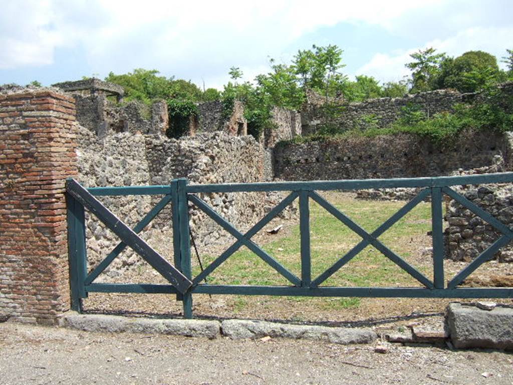 I.1.8 Pompeii. September 2005. Entrance. On the north (left) wall of the vestibule was formerly a Lararium painting - now destroyed. Beside a round altar stood the Genius, performing a sacrifice with the aid of tibicen and camillus, the latter of whom carried a shallow dish in one hand. The two Lares were on either side. Around the altar was a coiled serpent. In the lower zone there were two other serpents, one on each side of a masonry projection above which was painted a pine cone.
Between these two serpents was the figure of a man pouring wine from an amphora into a Dolium. Above his head was written the name of Hermes (CIL IV 3355). Presumably the name of the proprietor of the Hospitium. Opposite the painting, leaning against the south (right) wall, was a hearth for cooking. Near to the hearth was the door that led to No.6.
See Boyce G. K., 1937. Corpus of the Lararia of Pompeii. Rome: MAAR 14. (p.21)
See Della Corte, M., 1965. Case ed Abitanti di Pompei. Napoli: Fausto Fiorentino. (p.265)
See Fröhlich, T., 1991. Lararien und Fassadenbilder in den Vesuvstädten. Mainz: von Zabern. (p.249, L2)
See Pappalardo, U., 2001. La Descrizione di Pompei per Giuseppe Fiorelli (1875). Napoli: Massa Editore. (p.33)