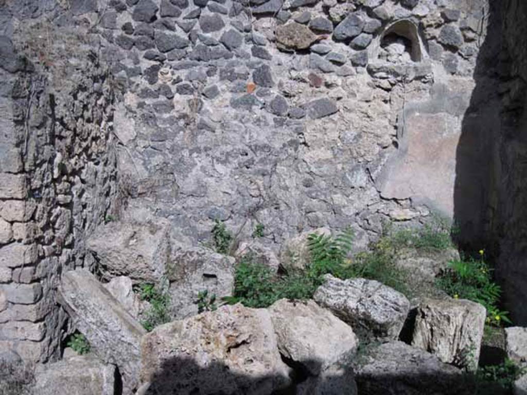 I.2.23 Pompeii. September 2010. East wall of entrance area, with niche. Photo courtesy of Drew Baker. According to Garcia y Garcia, the dividing wall of a rustic room in this area was destroyed due to the 1943 bombing.
See Garcia y Garcia, L., 2006. Danni di guerra a Pompei. Rome: L’Erma di Bretschneider. (p.37)