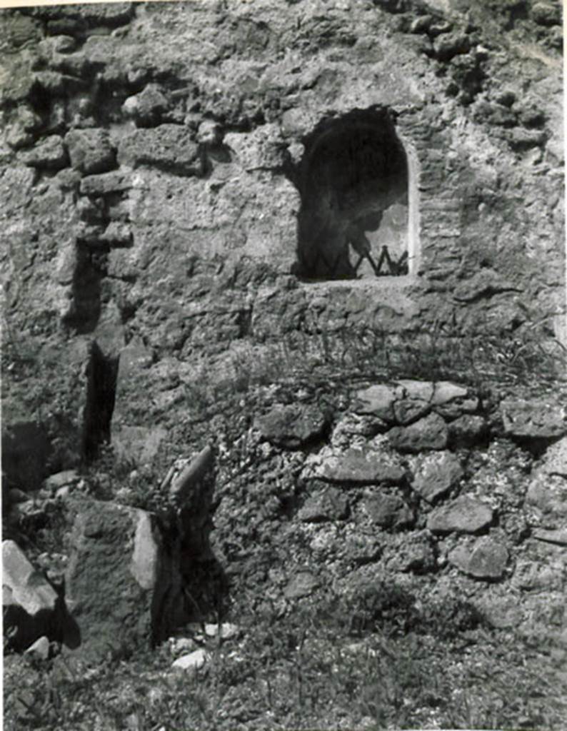 I.3.15 Pompeii. 1935 photograph taken by Tatiana Warscher. Looking towards arched niche in west wall.
See Warscher, T, 1935: Codex Topographicus Pompejanus, Regio I, 3: (no.31), Rome, DAIR, whose copyright it remains.
According to Warcher, quoting Fiorelli, “On the right of this workshop were the first steps of the stairs that went up to the upper floor, under which was a podium, with furnace in the middle to accommodate a large boiler, which was used as a laundry. Embedded in nthe wall was the niche for the Lares”.