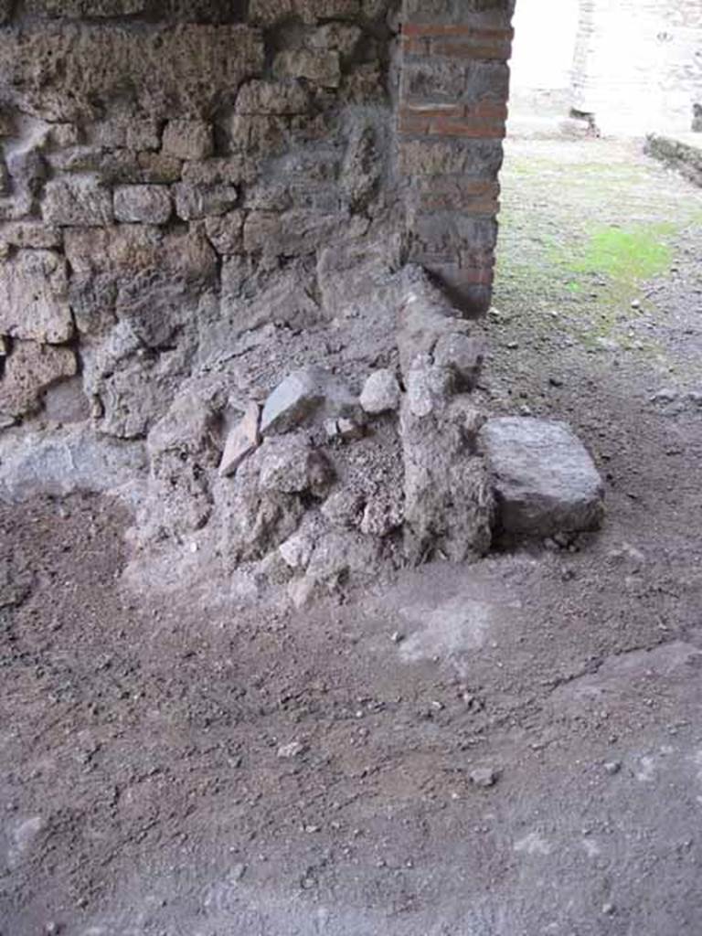 I.5.2 Pompeii. September 2010.
Looking north towards remains of masonry podium of lararium. Photo courtesy of Drew Baker.
According to Boyce, there was a ruined lararium in a room on the north-east side of the peristyle.
It was a solid podium (0.80 by 1.0, h. varies from 0.48 to 0.90) standing against the wall, with its three sides painted in imitation marble veneer.
There was a painted aedicula on the wall above it.
He quotes – Bull. Inst., 1874, 275; Fiorelli, Descr., 451.
See Boyce G. K., 1937. Corpus of the Lararia of Pompeii. Rome: MAAR 14. (p.25 no.33).