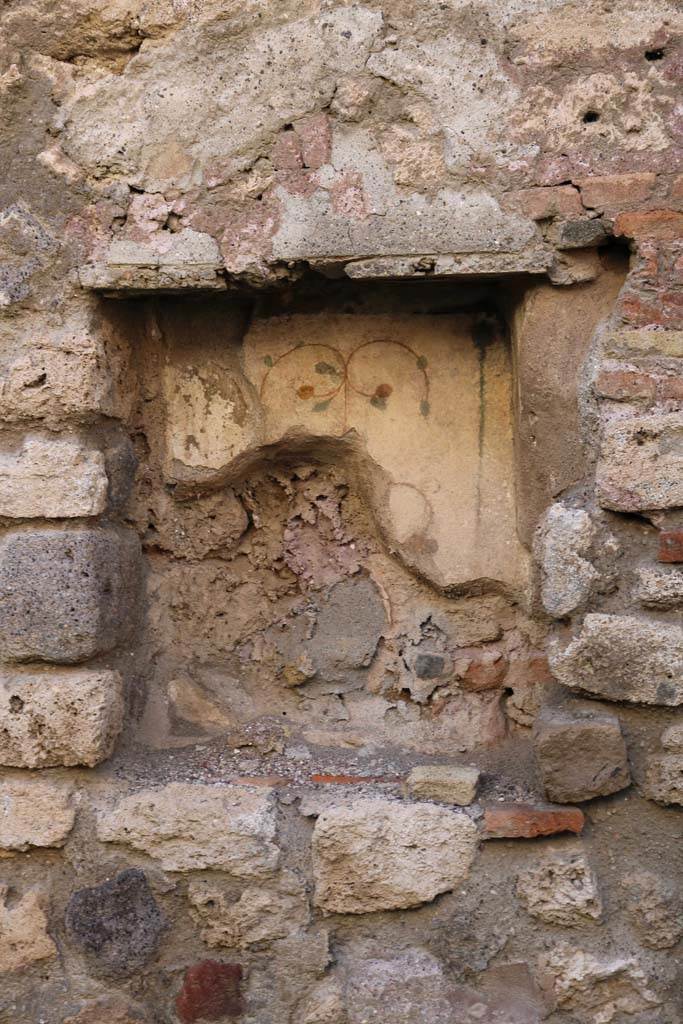 I.6.1 Pompeii. December 2018. West wall with rectangular niche. Photo courtesy of Aude Durand.
According to Boyce –
In the west wall is a rectangular niche (h.0.54, w.0.45, d.0.25, h. above floor 0.80).
Its walls were coated with white stucco and decorated with leaves and fruit, painted in red, green and yellow.
He quotes - Not Savi, 1913, 477.
See Boyce G. K., 1937. Corpus of the Lararia of Pompeii. Rome: MAAR 14. (p. 25, no.35).