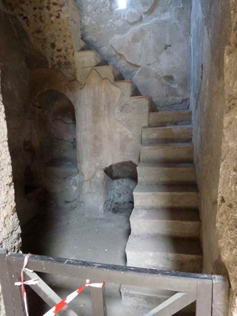 I.10.4 Pompeii. June 2012.
Room 2, small room on east side of aedicula lararium in atrium, with niche and recess below stairs to upper floor.
According to Boyce, in a small room with an arched recess beneath the stairs,
there was a small masonry altar with two cavities in the top, and a niche in the wall above.
See Boyce G. K., 1937. Corpus of the Lararia of Pompeii. Rome: MAAR 14. (p.28, no.50C).
He quoted his reference as MAIURI, Casa del Menandro, 37.
Photo courtesy of Michael Binns.