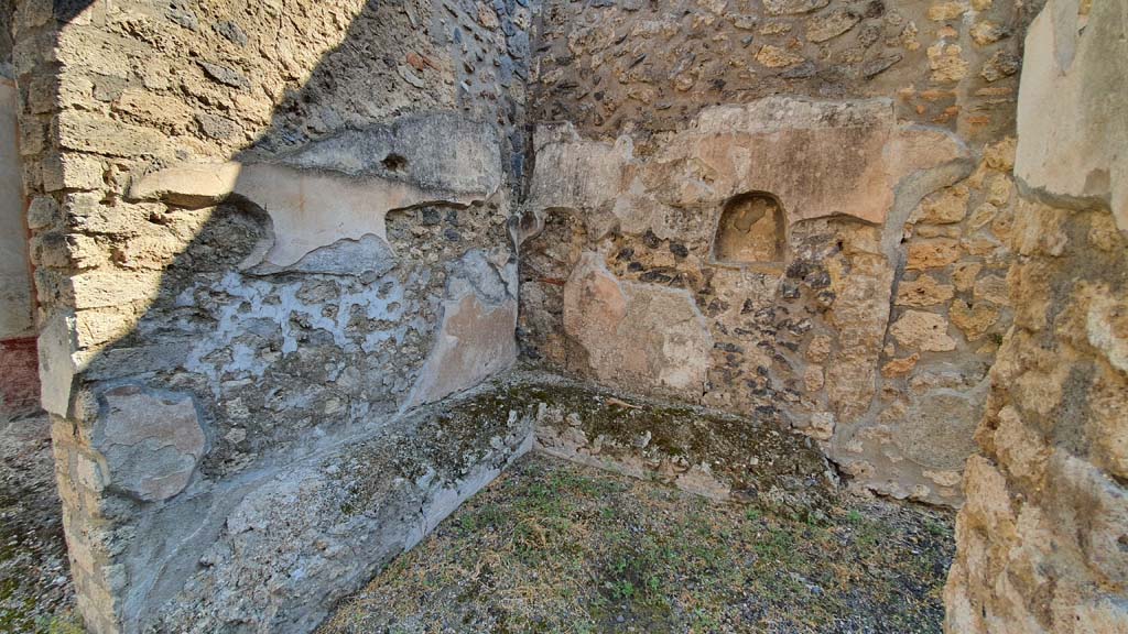 I.11.1 Pompeii. July 2021.
Room in south-east corner of bar-room with benches for the clients against the north and east walls and a lararium niche in the east wall.
Foto Annette Haug, ERC Grant 681269 DÉCOR.
According to PPM –
“After the fall (between 1977 and 1979) of the last layer of white plaster, the ancient painting of the Genius with a veiled head, sacrificing to the altar, had reappeared. The face of the genius had already been stolen before 1977.”
See Carratelli, G. P., 1990-2003. Pompei: Pitture e Mosaici: Vol. II. Roma: Istituto della enciclopedia italiana, (p.513).