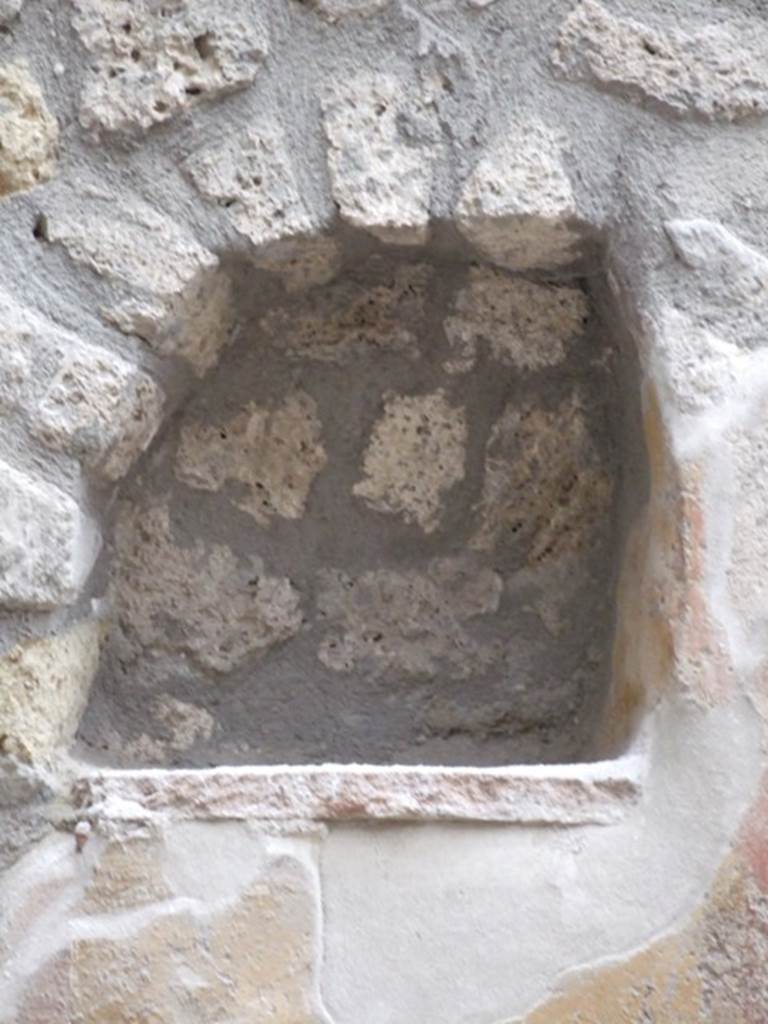 I.11.6 Pompeii. March 2009. Room 6, niche. Arched niche on east side of south wall in garden. According to Giacobello, the niche was found on a wall frescoed in yellow and was part of a painted wall decoration. The niche was made in the last period of the house, when the interior decoration of the garden was done. See Giacobello, F., 2008. Larari Pompeiani: Iconografia e culto dei Lari in ambito domestico. Milano: LED Edizioni. (p.257)