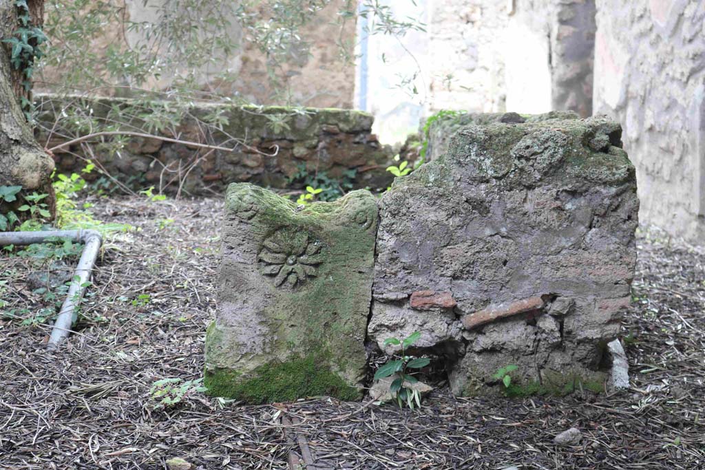 I.12.8 Pompeii. December 2018.
Room 9, peristyle garden. Low wall in north-west corner with decorative stone, separating portico from peristyle garden. Photo courtesy of Aude Durand.