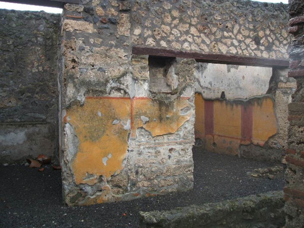 I.13.11 Pompeii. December 2004. Looking west across garden area.
Doorways to cubiculum on left, and oecus on the right, on west side of garden, with lararium niche between. According to PPP, on the west wall between doorways was the lararium niche, with serpent, red flowers and red border, much decayed. See Bragantini, de Vos, Badoni, 1981. Pitture e Pavimenti di Pompei, Parte 1. Rome: ICCD. (p.189)
According to Fröhlich and Giacobello, the rectangular niche was painted on its inside walls with red flowers, no longer conserved. There may have been two statuettes found in this lararium, Hercules and Minerva.
See Fröhlich, T., 1991. Lararien und Fassadenbilder in den Vesuvstädten. Mainz: von Zabern. (L31)
See Giacobello, F., 2008. Larari Pompeiani: Iconografia e culto dei Lari in ambito domestico. Milano: LED Edizioni. (p.233)
According to PPM, the lower yellow zoccolo was divided into two panels by a vertical red band. On the south end was a painted vignette showing two doves with cherries, and at the north end under the niche was the painted lararium showing two serpents approaching a central altar with eggs.
See Carratelli, G. P., 1990-2003. Pompei: Pitture e Mosaici. Vol.II Roma: Istituto della enciclopedia italiana. (p.916).