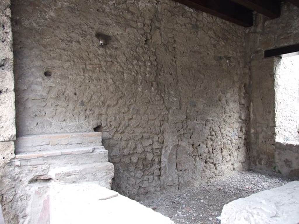 II.1.1 Pompeii. December 2006. Counter and east wall.
In the south-east corner there was a niche of a lararium to Venus which is no longer visible.
According to Boyce, the arched niche (h.0.28, w.0.35, d.0.20, h. above floor 1.50) on the east wall had a painted blue border.
In front of it stood a small table (0.48 by 0.17) decorated with metopes.
Nothing was found in the niche, but when the soil under the niche was investigated, fragments of a pseudo-alabaster statuette of Venus was found.
It was of very rough workmanship but had been gilded originally.
In front of the image of the goddess stood a small altar of terracotta.
See Boyce G. K., 1937. Corpus of the Lararia of Pompeii. Rome: MAAR 14. (p. 30, no. 61)
Boyce gives a reference to Not. Scavi 1917, 251, with a photograph of the statuette, on p. 253.
.