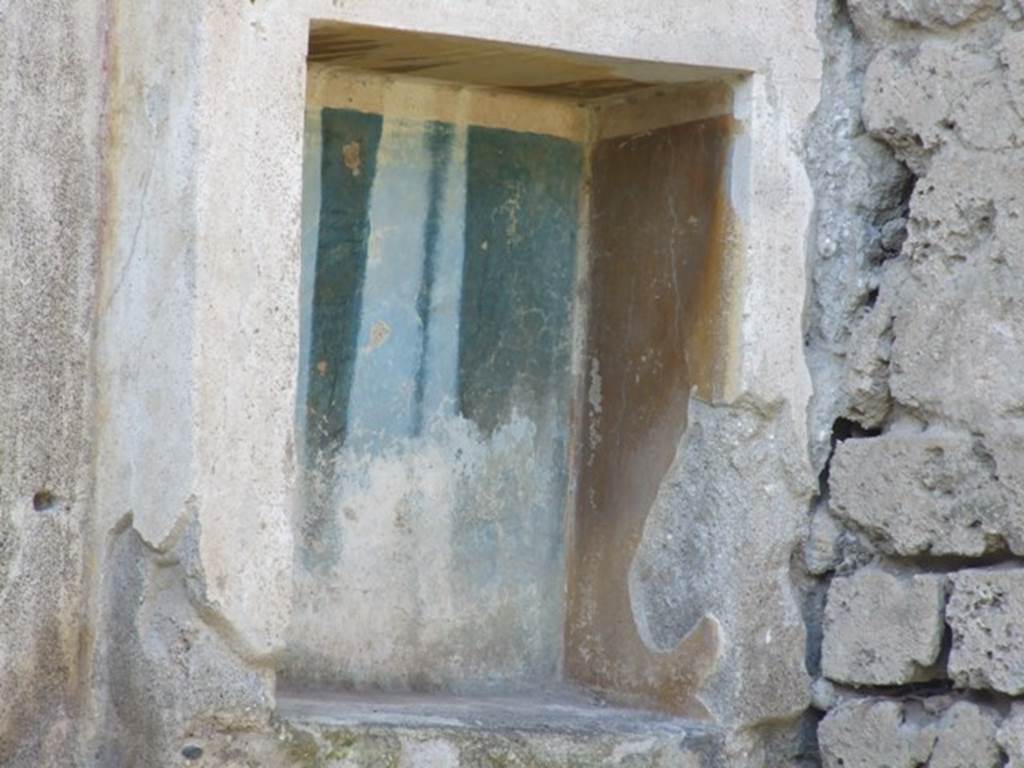 III.4.1 Pompeii. March 2009. Rectangular niche on west wall, with yellow and blue walls inside the niche.
According to Boyce –
In the west wall is a rectangular niche (h.0.58, w.0.34, d.0.25, h. above floor 1.20) with an aedicula façade painted on the wall around it.
Two pilasters supported a white architrave and a blue pediment which was ornamented with a white disc in the centre and surrounded by white cornices.
The side walls within the niche were yellow, the back wall was blue, and the corners white.
See Boyce G. K., 1937. Corpus of the Lararia of Pompeii. Rome: MAAR 14. (p.30, No.65, Pl.1, 6)