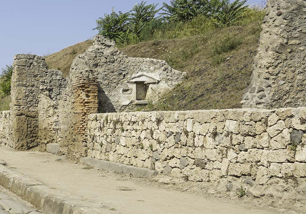 III.7.5 Pompeii. August 2021.
Wide threshold of doorway in centre, under new wall, on north side of Via dell'Abbondanza.
A niche with a pediment can now be seen, set into the west wall.
The narrow threshold of III.7.4 is on the left. Photo courtesy of Robert Hanson.