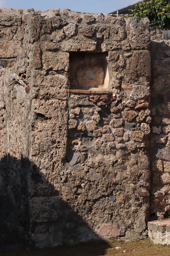 V.2.14 Pompeii. October 2022.
Pilaster with niche Lararium in north wall of shop. Photo courtesy of Klaus Heese.
