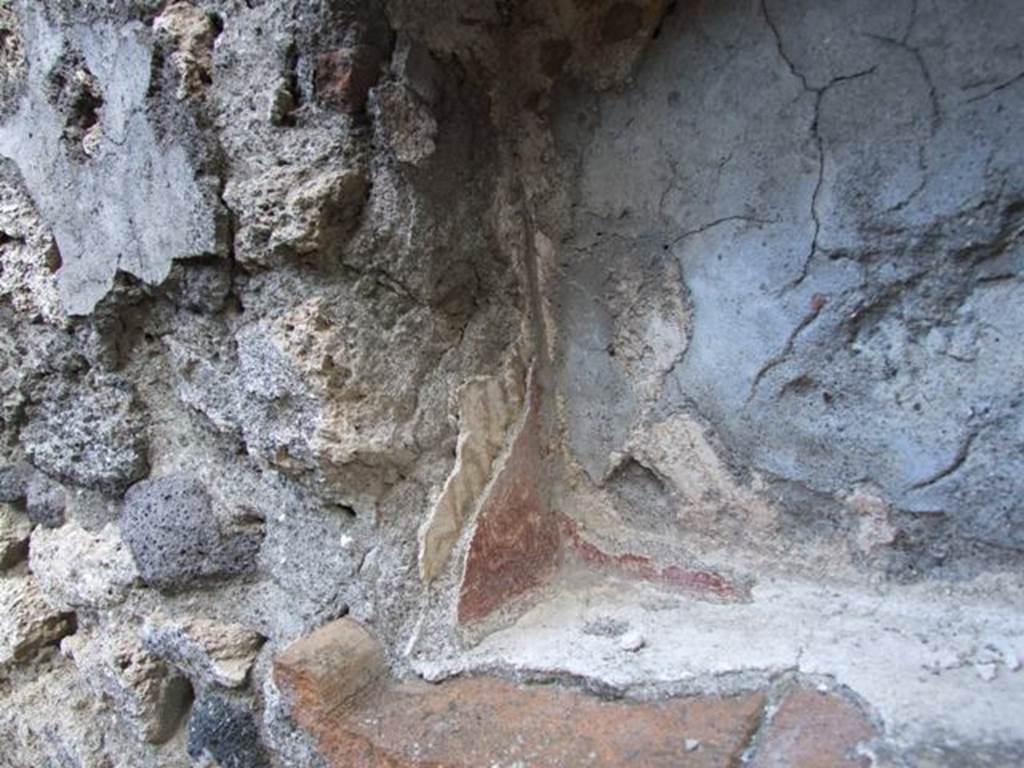 V.2.15 Pompeii. December 2007. Room 9. Lararium. Remains of several layers of superimposed decorated painted plaster in niche. According to Boyce, red flowers were painted on the earlier white stucco on the side walls. On the rear wall was a figure in yellow, perhaps a Lar, but only his feet were visible. Today, nothing remains. See Boyce G. K., 1937. Corpus of the Lararia of Pompeii. Rome: MAAR 14. (No.95B on p.35)