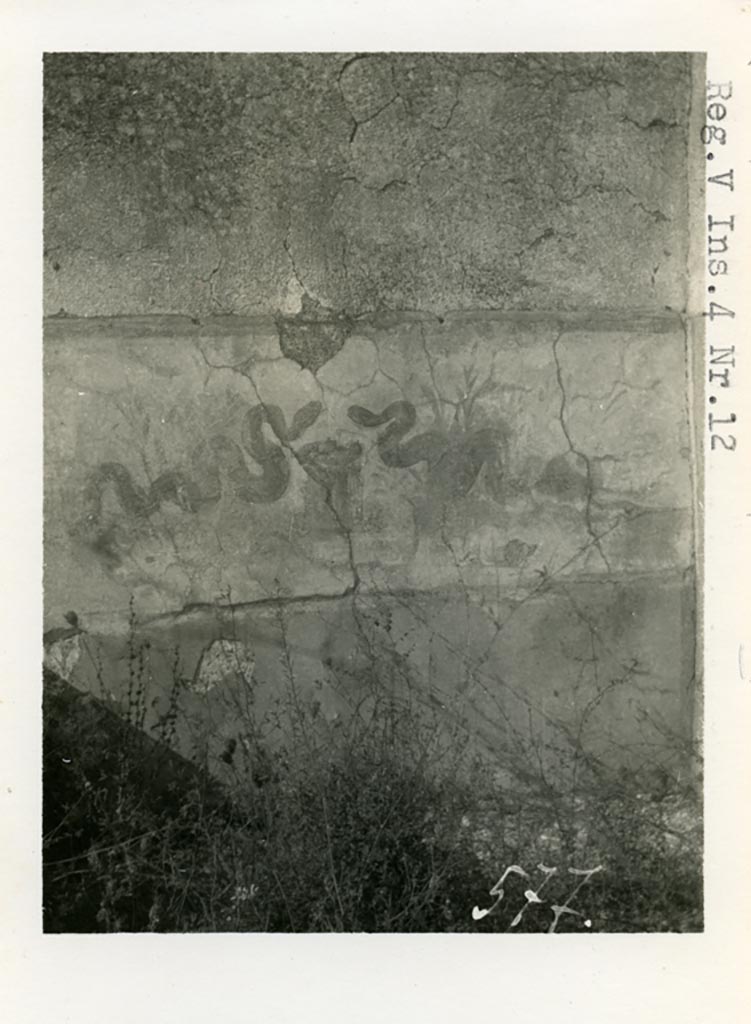 V.4.13 Pompeii but shown as V.14.12 on photo. Pre-1937-39. Two painted serpents.
Photo courtesy of American Academy in Rome, Photographic Archive. Warsher collection no. 577.
According to Boyce –
Around the corner from this niche, on the west wall of the open area which preceded the garden on the north, was a broad sheet of white plaster.
On this plaster were painted two yellow serpents near a cylindrical altar with fruit, in the background were plants.
See Boyce G. K., 1937. Corpus of the Lararia of Pompeii. Rome: MAAR 14. (p.42, no.126, Pl. 11,2).
