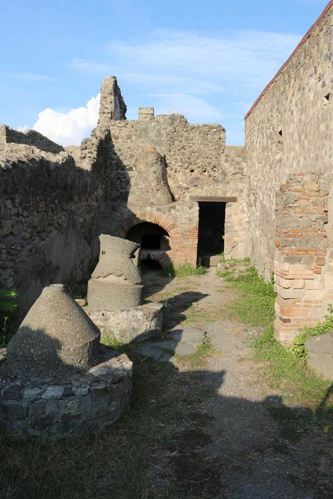VI.2.6 Pompeii. December 2018.
Looking east towards oven, from entrance. Photo courtesy of Aude Durand.
According to Boyce –
in the north wall of the room behind the oven was a large rectangular niche (h.0.90, w.0.60, d.0.40, h. above floor 1.50).
See Boyce G. K., 1937. Corpus of the Lararia of Pompeii. Rome: MAAR 14. (p.44, no.140)