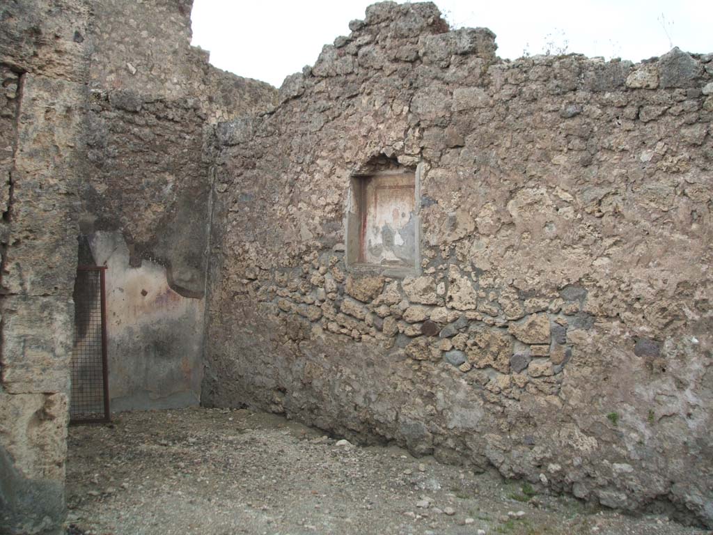 VI.7.9 Pompeii. May 2005. West wall of south ala, with niche with small painting of the head of the Gorgon.
According to Frohlich and Giacobello, on the west wall of the atrium, was a niche with a painted mask on a white background.
A painted lararium was also documented but of this there is no trace, according to them.
See Fröhlich, T., 1991. Lararien und Fassadenbilder in den Vesuvstädten. Mainz: von Zabern. (L63, Picture 34,1)
See Giacobello, F., 2008. Larari Pompeiani: Iconografia e culto dei Lari in ambito domestico. Milano: LED Edizioni. (p.242)
According to Sogliano, in the kitchen was a painted lararium of an altar and a serpent nearby.
See Sogliano, A., 1879. Le pitture murali campane scoverte negli anni 1867-79. Napoli: (p.17, no.48).
(The kitchen would have been on the north side, at the rear of the stairs, and has not yet been photographed).
According to Boyce, Helbig wrongly assigned the shrine from VI.7.7, to VI.7.9 (see VI.7.7)
See Boyce G. K., 1937. Corpus of the Lararia of Pompeii. Rome: MAAR 14. (p.47, no.163, note 1)