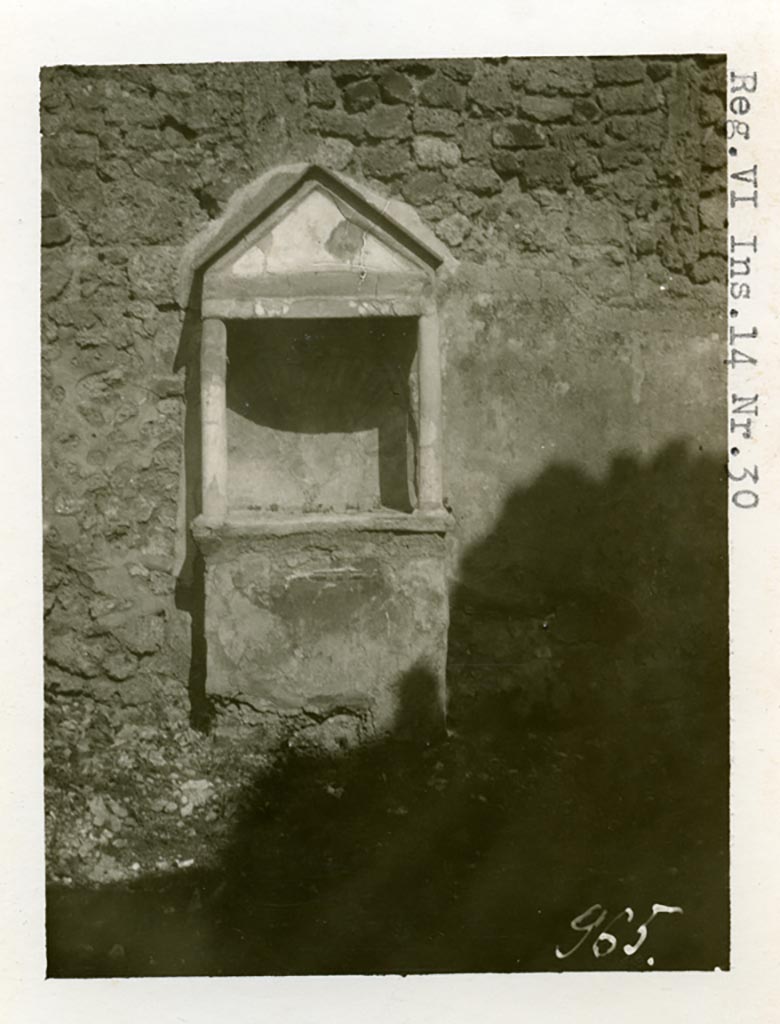 VI.14.30 Pompeii. Pre-1937-39. Aedicula against east wall of garden.
Photo courtesy of American Academy in Rome, Photographic Archive. Warsher collection no. 965.
According to Boyce, against the east wall of the garden stands an aedicula (h.2.10).
Above a solid base (0.88 by 0.28, h.0.85), two columns without capitals (h.0.72) support a pediment.
In the tympanum is painted a large aquatic bird of reddish colour with wings spread.
It stands upon a black cloth, across its wings lies a black cord ending in a bow-knot, on each side of the bird stands a green marine goat.
The base of the aedicula is black, adorned with a painted garland.
The rear wall within the shrine is hollowed out in the form of a seashell and painted in imitation of one.
In the south wall of the same garden is a niche with projecting floor and vaulted ceiling.
Its walls are adorned with painted plants, flowers and birds.
We can only speculate on the purpose of this niche.
Presumably the aedicula is the lararium, the niche probably contained a figure of primarily decorative character.
See Boyce G. K., 1937. Corpus of the Lararia of Pompeii. Rome: MAAR 14. (p.53, no.203, and Pl. 35,1)
According to Giacobello, the painted decoration on the aedicula and architecture has disappeared, leaving only the stone podium and the niche.
The wall was decorated with a rich garden painting.
Regarding the niche on the south wall of garden, originally painted with flowers, plants and birds, today disappeared, only the red plaster remains.
See Giacobello, F., 2008. Larari Pompeiani: Iconografia e culto dei Lari in ambito domestico. Milano: LED Edizioni. (p.275 no.V54)