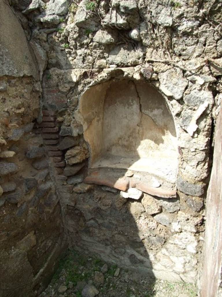 VI.15.6 Pompeii. March 2009. Room 9, north wall with niche. According to Boyce, in a little room on the south side of the house, is an arched niche in the north wall. It has white inside walls and projecting floor.
Just above the shrine were the marks made where some twenty-five nails had been driven into the wall. Not.Scavi, 1897, 31.
See Boyce G. K., 1937. Corpus of the Lararia of Pompeii. Rome: MAAR 14. (p.55, no.213) See Giacobello, F., 2008. Larari Pompeiani: Iconografia e culto dei Lari in ambito domestico. Milano: LED Edizioni. (p.291)