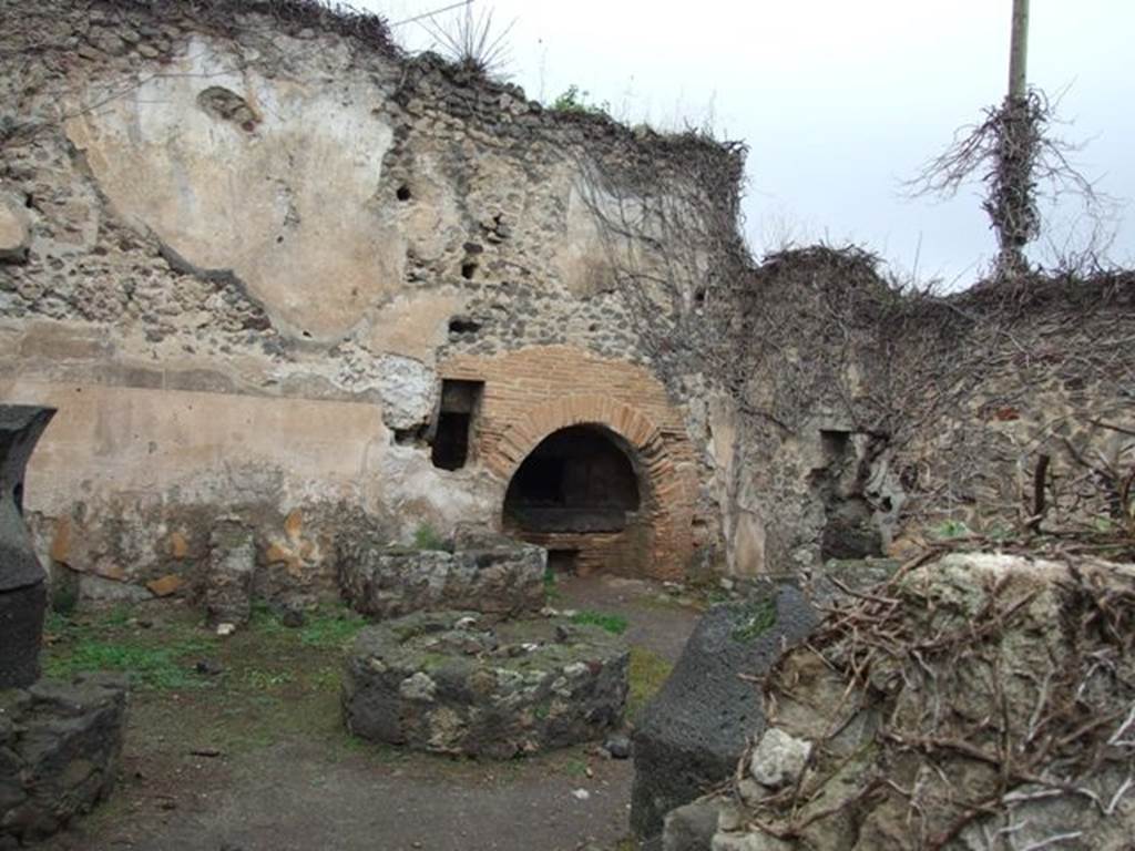 VII.2.3 Pompeii. December 2007. Bakery with mills, basin and oven.
Boyce and Fiorelli state that on one of the walls of the pistrinum was a faded lararium painting. Boyce said that in the centre was an altar and at its side was a seated Vesta, with her right hand she was pouring a libation onto the altar. Behind her shoulder was an ass. On the other side of the altar was the Genius, also pouring a libation onto the altar.
On each side of this central group was a wreathed Lar, wearing tunic, pallium and high boots, and holding a patera and rhyton. Across the top of the painting was a garland.
See Boyce G. K., 1937. Corpus of the Lararia of Pompeii. Rome: MAAR 14. (p. 61, 247)
See Pappalardo, U., 2001. La Descrizione di Pompei per Giuseppe Fiorelli (1875). Napoli: Massa Editore. (p. 80)