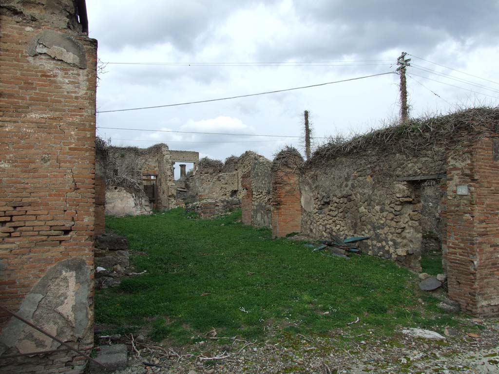 VII.4.26 Pompeii. December 2007. Shop entrance to workshop/dwelling.
According to Fiorelli, the atrium with an impluvium would have been at the rear of the shop-room, on whose right side would have been positioned the ala, the storeroom containing the stairs to the upper rooms, and the cubiculum decorated with gladiatorial scenes.
At the rear, there was a small room bordered by the corridor, as well as a triclinium with entrance from the same corridor, which in its length gave access to three other rooms, a small garden and the kitchen, which had a separate latrine, and in the wall against the hearth showed a painting with Hercules before the altar, assisted by the Tibicine between the two Lares: in the lower part of the painting were two men with an amphora, and other amphorae on a cart. On the side wall, were the painted serpents and table.
See Pappalardo, U., 2001. La Descrizione di Pompei per Giuseppe Fiorelli (1875). Napoli: Massa Editore. (p.90).