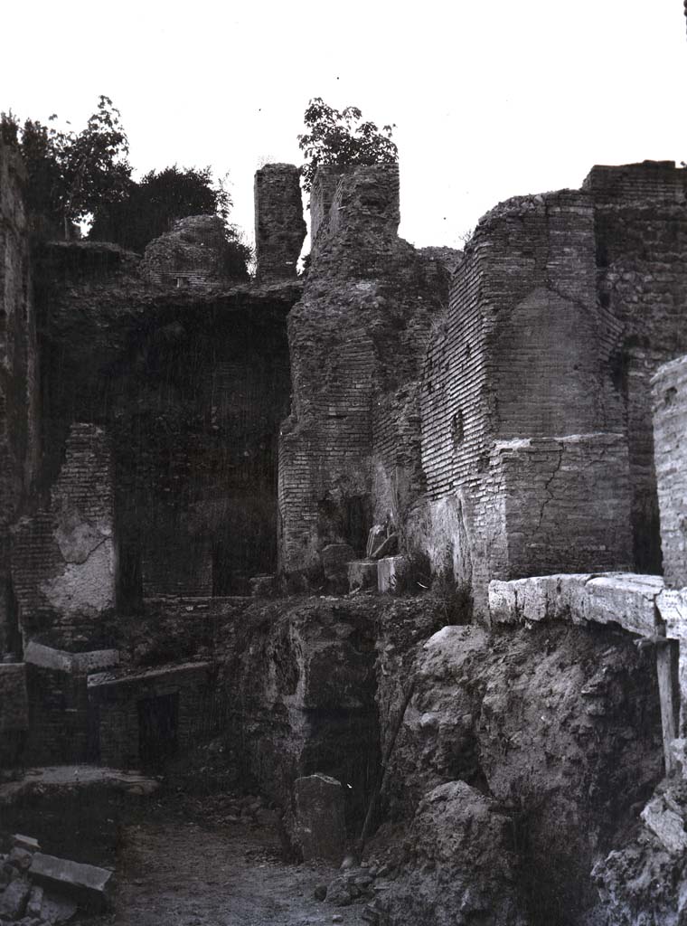 PL.1. Pompeii. Photo by Esther Boise Van Deman (c) American Academy in Rome. VD_Archive_Ph_241.
Description given as Pompeii, Oven, and photo from between 1900-1930.
It does not seem to correspond to any of the ovens in bakeries, the walls look too big to be from a house.
Perhaps the photo is from a Villa, now reburied.
Ostia has been suggested to us, but we wrote to them and they answered that it was not from there.
Espen B Andersson has suggested:
This photo seems to show the entrance to the hypocaust in a Baths building, possibly in Rome.
So much was lost in Rome in the 19th and early 20th century, for instance by the construction in 1936 of the ‘Viale del Monte Oppio’ which goes across Baths of Trajan and made severe damage to the archaeological remains. 
Can anyone add anything further as to the identity of this intriguing photograph, as we would love to accurately locate it.
