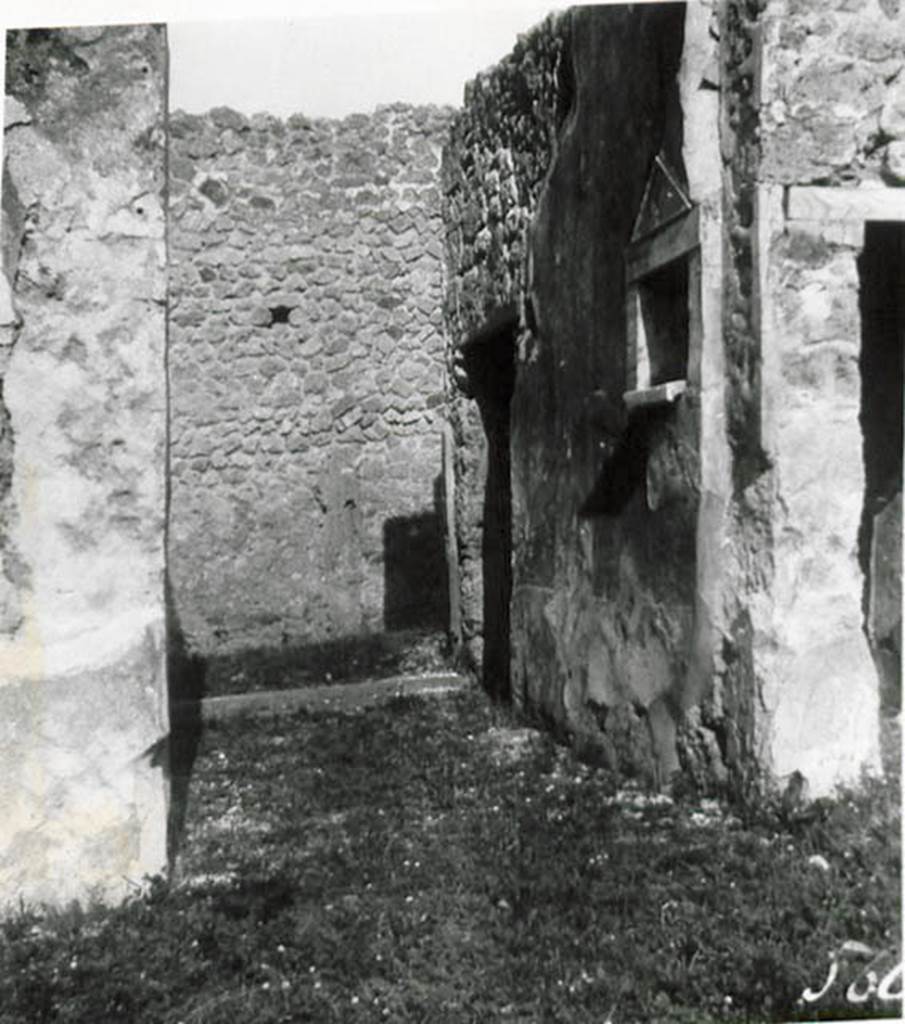 1.2.17 Pompeii. 1935 photo taken by Tatiana Warscher. Looking north along entrance corridor towards doorway.
See Warscher T., 1935. Codex Topographicus Pompeianus: Regio I.2. (no.28), Rome: DAIR, whose copyright it remains.
According to Warscher, quoting Bull. Inst, 1874, p.264 � I.2.17 �La fauces che hanno la soglia di lava, s�abbassano un poco verso l�interno.  Nel muro sinistra vi � una piccola nicchia con suole e cornice di marmo a guisa d�un tempietto. Nel suole di essa sono tre buchi, uno pi� profondo degli altri destinati probabilmente per mettervi piccoli idoli, come la lastra sporgente del suolo serviva per oblazioni. Presso gli angoli che formano le fauces coll�atrio manca lo stucco del muro, e nel suolo su ciascun lato si vede una pietra di lava: evidentemente vi stavano li postes di legno�.
(translation: I.2.17 �The fauces that had a threshold of lava, led slightly downwards towards the atrium. In the left wall there was a small niche with floor and cornice of marble, in the guise of a shrine. In the floor were three holes, one deeper than the others, which was used probably for a small idol, and the protruding slab of the floor was used for donations. Near the corner that joined the fauces with the atrium, the wall stucco was missing and in the floor on that side one could see a slab of lava: evidently there were wooden posts�.) 
