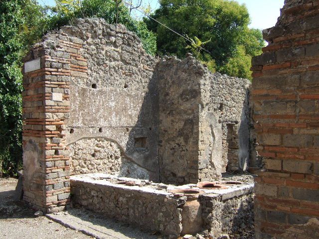 I.2.18 Pompeii. September 2010. Looking west across rear of bar from near room in south-east corner, towards doorway to rear room in south-west corner (centre left). Photo courtesy of Drew Baker.