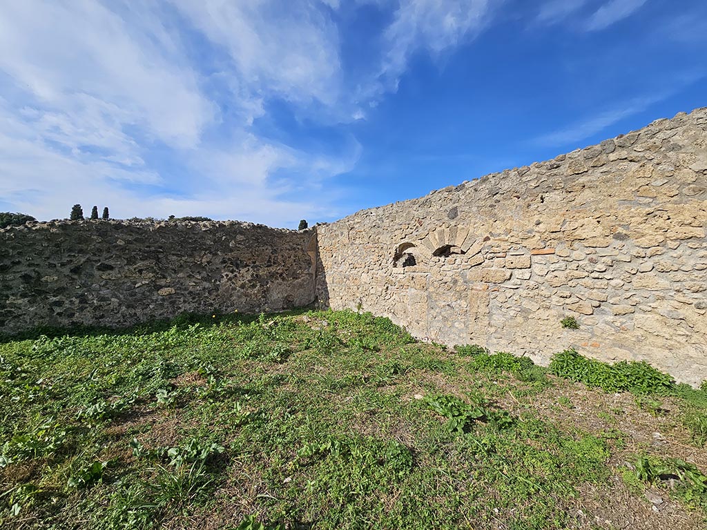 I.2.20 Pompeii. November 2024.
Looking towards north-west corner and masonry biclinium of garden area, with niche in north wall. Photo courtesy of Annette Haug.