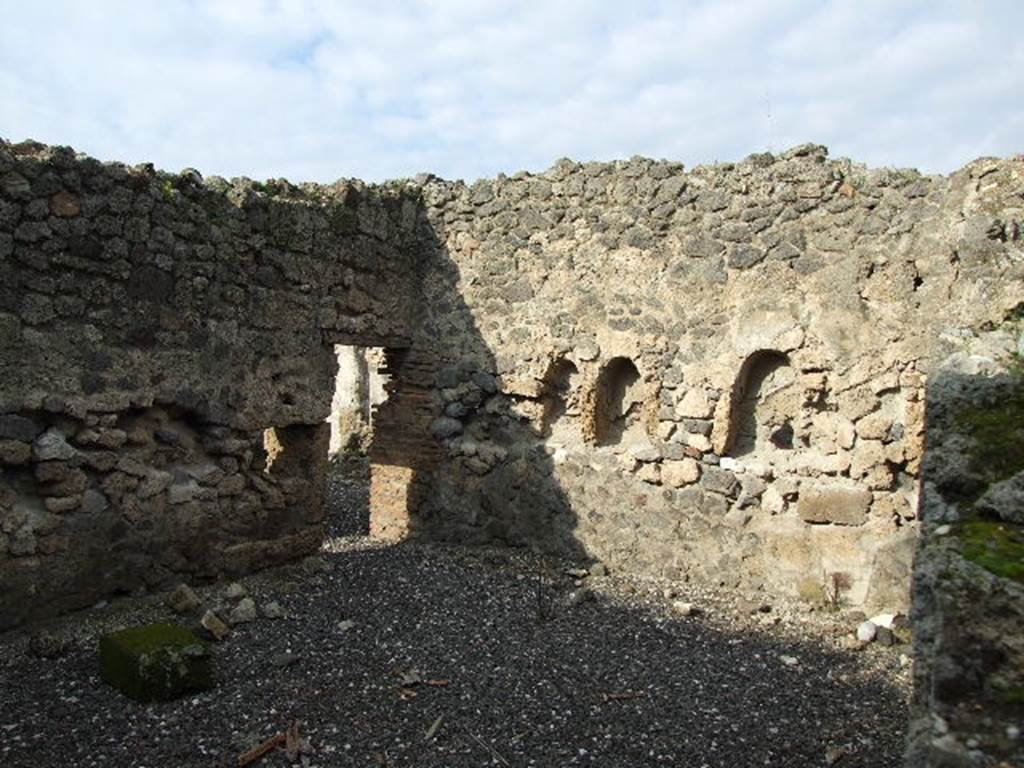 I.3.8b Pompeii. December 2006. North-west corner of kitchen on east side, through hole in wall from I.3.25. According to Boyce, two arched niches were found on the north wall of the kitchen. The niches were 0.58 high and 0.36 wide, 0.30 deep and 1.10 above the floor.
The niches were side by side, and 0.60 apart. He said Fiorelli described them as “nicchie per i domestici Lari”.
See Boyce G. K., 1937. Corpus of the Lararia of Pompeii. Rome: MAAR 14. (p. 24)