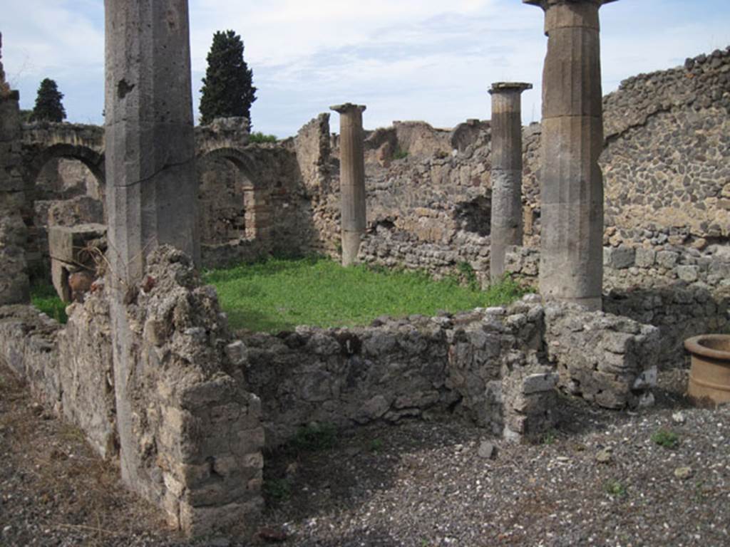 I.3.8b Pompeii. September 2010. Looking towards north-west corner of peristyle, from south-east corner. Photo courtesy of Drew Baker. According to Trendelenburg -
“I must mention the hearth of the peristyle that one finds near to a column of the east side, the vault of which was surmounted by a decoration, that I do not know, and until now is new in Pompeii. It is worth saying it was of a small bearded head with a pileus or falet cap.
It was crudely formed in terracotta and seemed to be made of the same bricks that made the hearth. Originally, above the head was a phallus (see GdS, 3 Sett.1869) that is missing today, and also missing is the glass paste, that made the eyes distinct.
The decoration is reputedly the head of Vulcan that elsewhere we see attributed to Vesta, as the tutelary god of the hearth”. See Trendelenburg in BdI, 1871, (p.171-2)