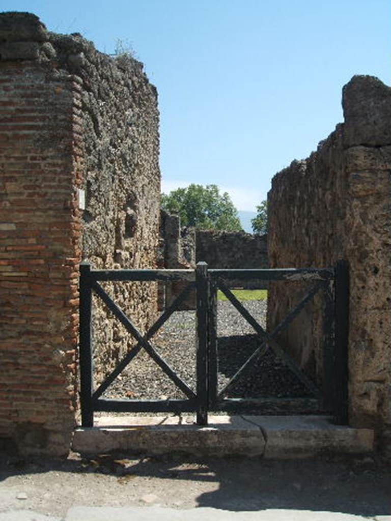 I.3.20 Pompeii. May 2005. Entrance doorway. According to Warscher, “Il protiro conduce in un atrio privo dell’impluvio. A destra una ampia cella con tre poggiuoli di fabbrica, per sostegno di un pancone di tavola, e di fronte il tablino. Nel viridario sono infissi due dolia.”
(Translation: The entrance corridor into an atrium without an impluvium.
On the right a large room with three masonry blocks, for the support of a board for the table, and the tablinum opposite. In the garden area were two dolia fixtures. "
