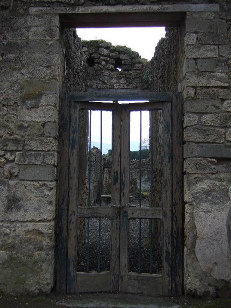 I.3.24 Pompeii. December 2005. Entrance doorway. According to Garcia y Garcia, a plaster cast of a portion of the entrance doorway with two shutters (leafs), half closed, with lock, door-bolt, hinge and iron doorlock, and provenanced from the doorway at I.3.24, used to be seen in the Antiquarium prior to the 1943 bombing.
See Garcia y Garcia, L., 2006. Danni di guerra a Pompei. Rome: L�Erma di Bretschneider, (p.184, fig.427).
