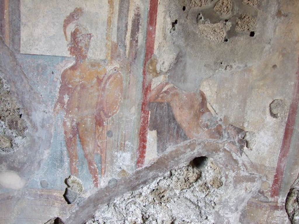 I.3.25 Pompeii. December 2006. Oecus, east wall. 
Detail of wall painting of Apollo in judgement. His right arm rested on a chair and was supporting his head in thought. 
A warrior to the left symbolised beauty.
Kuivalainen believes the figure on the right (head and feet destroyed) to be Bacchus.
See Kuivalainen, I., 2021. The Portrayal of Pompeian Bacchus. Commentationes Humanarum Litterarum 140. Helsinki: Finnish Society of Sciences and Letters, (p.104, B18).
