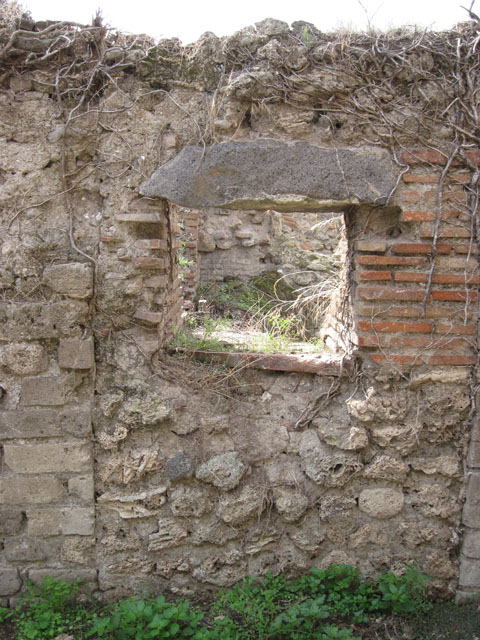 I.3.27 Pompeii. September 2010. Looking north with detail of grindstone in room on south side of bakery room, on east side of oven. Photo courtesy of Drew Baker.