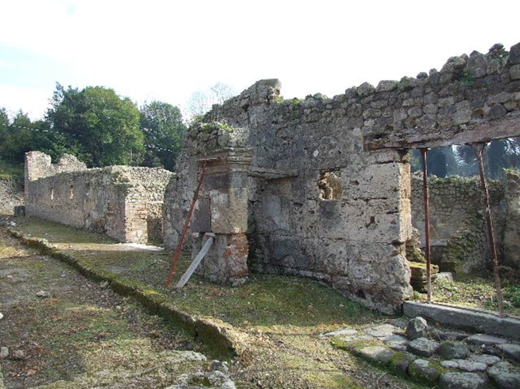 I.5.1 Pompeii. December 2006. Remains of portico or structure outside the entrance. Looking east along north side of I.5. This area was badly damaged by a bomb falling onto the north-west corner of this insula, during the night between 14th and 15th September 1943. The pedestrian bridge formed by a large piece of Sarno stone, between insula I.5 and I.2 was demolished. It also demolished the west pilaster and part of the east wall of the vestibule of entrance number I.5.1.
See Garcia y Garcia, L., 2006. Danni di guerra a Pompei. Rome: L’Erma di Bretschneider. (p. 37)