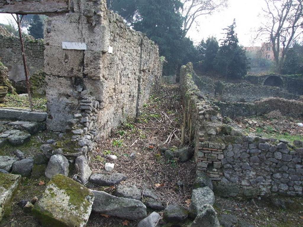 I.5.1 Pompeii. December 2006. Unnamed vicolo looking south, between 1.5 and I.1.
Warscher quoting Mau in Bull. Inst.1875, p.25, described Vicolo del Conciapelle as Via tertia, - “L’insula 5 della Regione I e quasi tutta occupata dalla conceria. Fuori di essa non vi è che il compreso rozzo sul lato E ed una bottega con tre camere sul cantone NO”
Quoting Sogliano in Giorn, Sc. III, no.21, 1874, p.8, she wrote –
“Chiameremo 5 per l’ordine cronologico dei cavamenti quest’isola della I Regione, la quale per essere parallela e vicina alla I doverebbe piuttosto dirsi 2. Considerando la parte finora scoverta, osserviamo a prima vista che la sua costruzione offre in taluni punti grandi lastre del tufo di Sarno, in altri quello di Nocera, e per lo più l’opus incertum. I tre vicoli, che rasentano ad oriente, settentrione ed occidente, non sono lastricati; il settentrionale è accessibile solo per i due altri margines, ricongiunti nel mezzo di esso da un piccolo ponte in fabbrica. Quest’isola, per la sua situazione presso la porta Stabiana e per la sua località, sembra sia stata abitata in gran parte da persone viventi col commercio e coll’industria”.
See Warscher T., 1936. Codex Topographicus Pompeianus: Regio I.1, I.5. Rome: DAIR, whose copyright it remains.