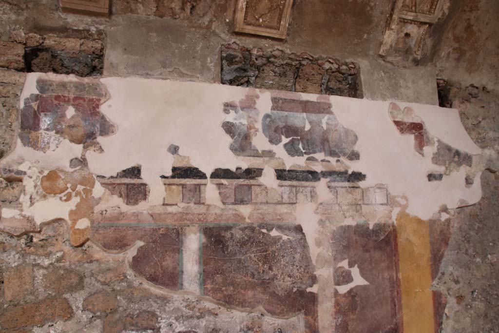 I.6.2 Pompeii. September 2019. Detail from north wall of north wing of cryptoporticus. Photo courtesy of Klaus Heese.
According to PPM, this frieze continues to show scenes from the Iliad.
On the left is the head of a maenad.
After a gap, the iliac narrative continues with the exchange of weapons between Glaucus and Diomedes, whose name is recorded at his feet in Greek.
On the right, is a fighter on a chariot, assisted by a cloaked figure.
Diomedes can be recognized, who, assisted by Athena, fights Ares or Aeneas.
See Carratelli, G. P., 1990-2003. Pompei: Pitture e Mosaici: Vol. I. Roma: Istituto della enciclopedia italiana, p. 204.