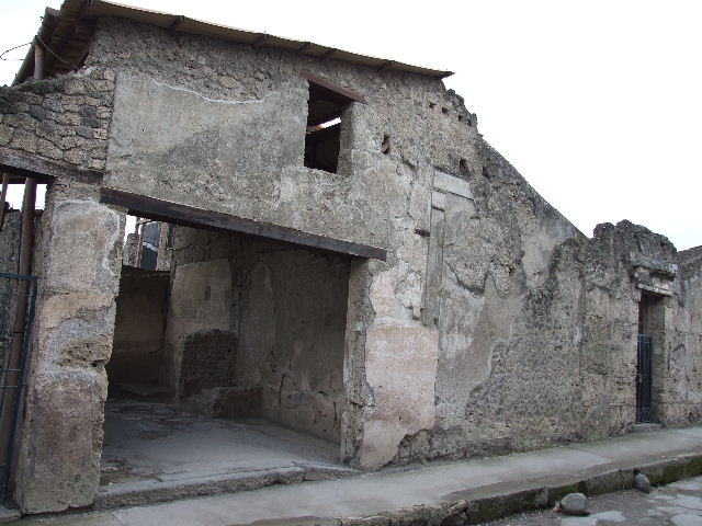I.6.3 Pompeii. May 2005. Looking south, across workshop with steps to upper floor on the right, to rear room with window.