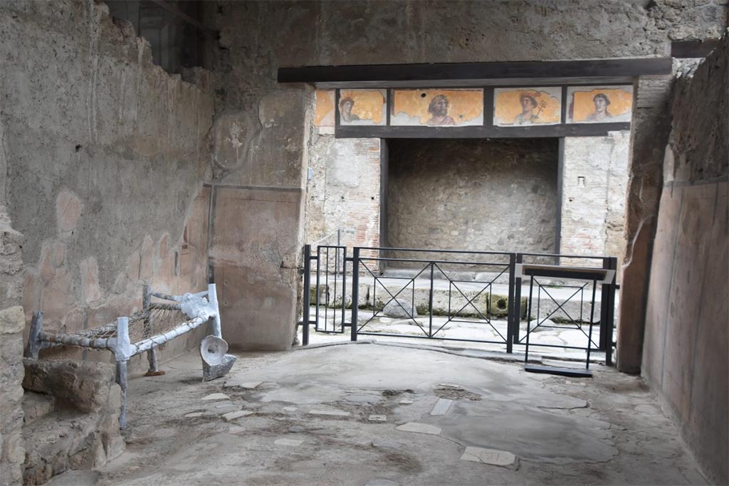 I.6.3 Pompeii. December 2023. Looking north past the reconstruction (copy of the plaster-cast) of a slave’s cot against west wall.
