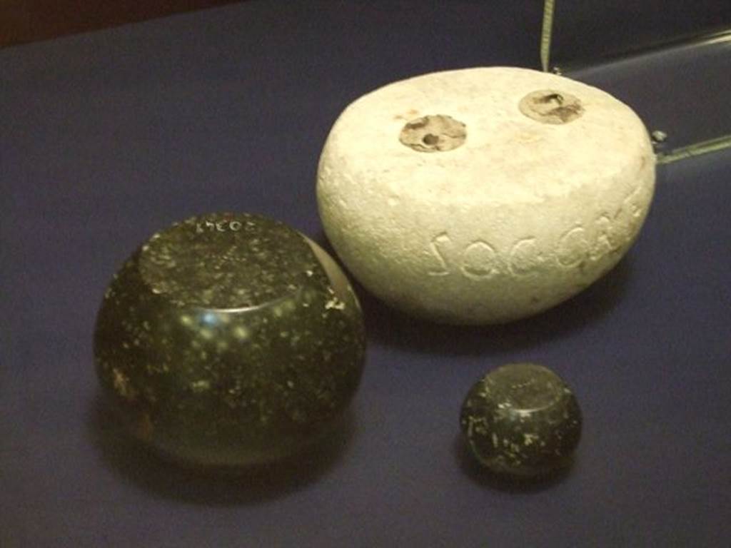 I.6.13 Pompeii. Round white limestone weight.  SAP inventory number 3918.  
The two other black basalt weights were found somewhere in Pompeii, the larger one has SAP 20349 on it. 
Photographed at �A Day in Pompeii� exhibition at Melbourne Museum.  September 2009.

