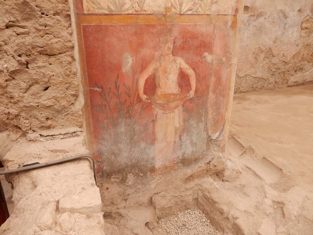 I.6.15 Pompeii. June 2019. Room 9, small garden.
Wall on west side. Painting with birds, plants and a figure holding a basin or bowl.
Photo by Buzz Ferebee.