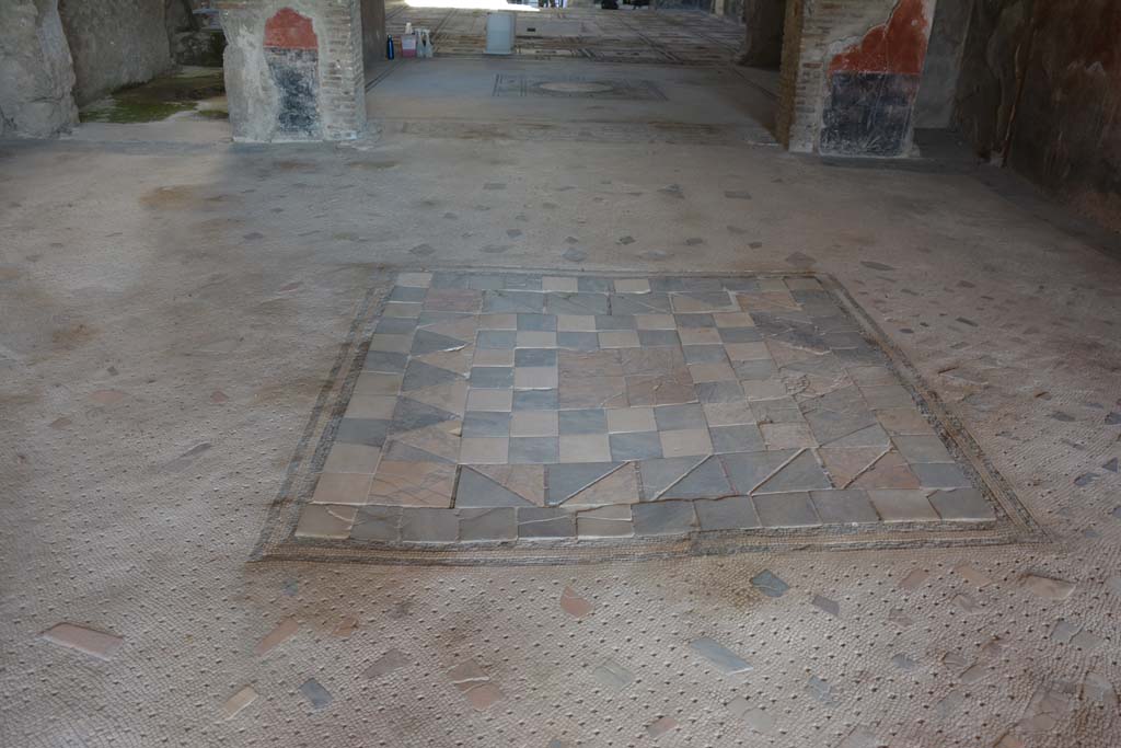 I.7.1 Pompeii. October 2019. Flooring in oecus, looking south across tablinum towards atrium.
Foto Annette Haug, ERC Grant 681269 D�COR.
In the centre of the floor of the oecus was an emblema in opus sectile of coloured marble.
This was made from square tiles with contrasting triangles and edged with a double black mosaic band.


